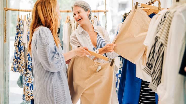 Fashionable middle-aged women shopping for clothes in a fashion boutique.