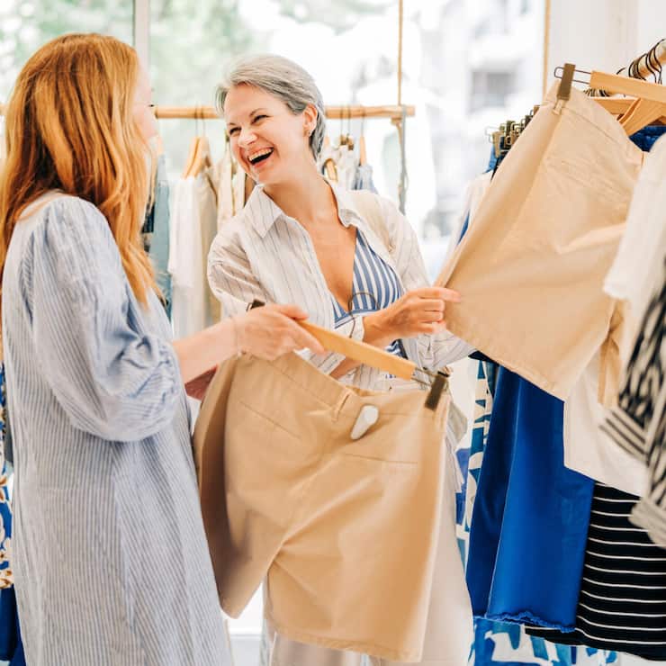 Fashionable middle-aged women shopping for clothes in a fashion boutique.